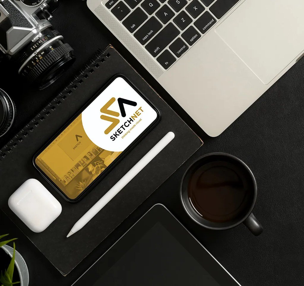 SketchNet brand stationery — business card, notebook and coffee on a studio desk